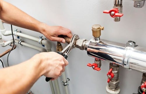 a plumber working on pipes in a commercial facility